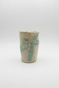 Ceramic vase with blue palm design on a white surface