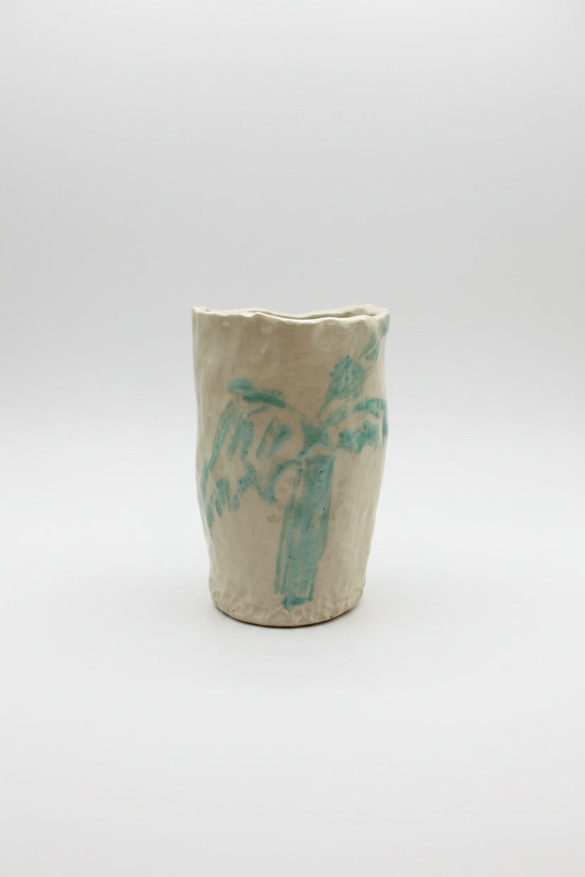 Ceramic vase with blue palm design on a white surface