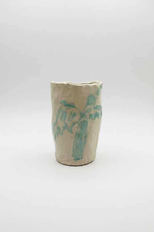Ceramic vase with blue palm design on a white surface