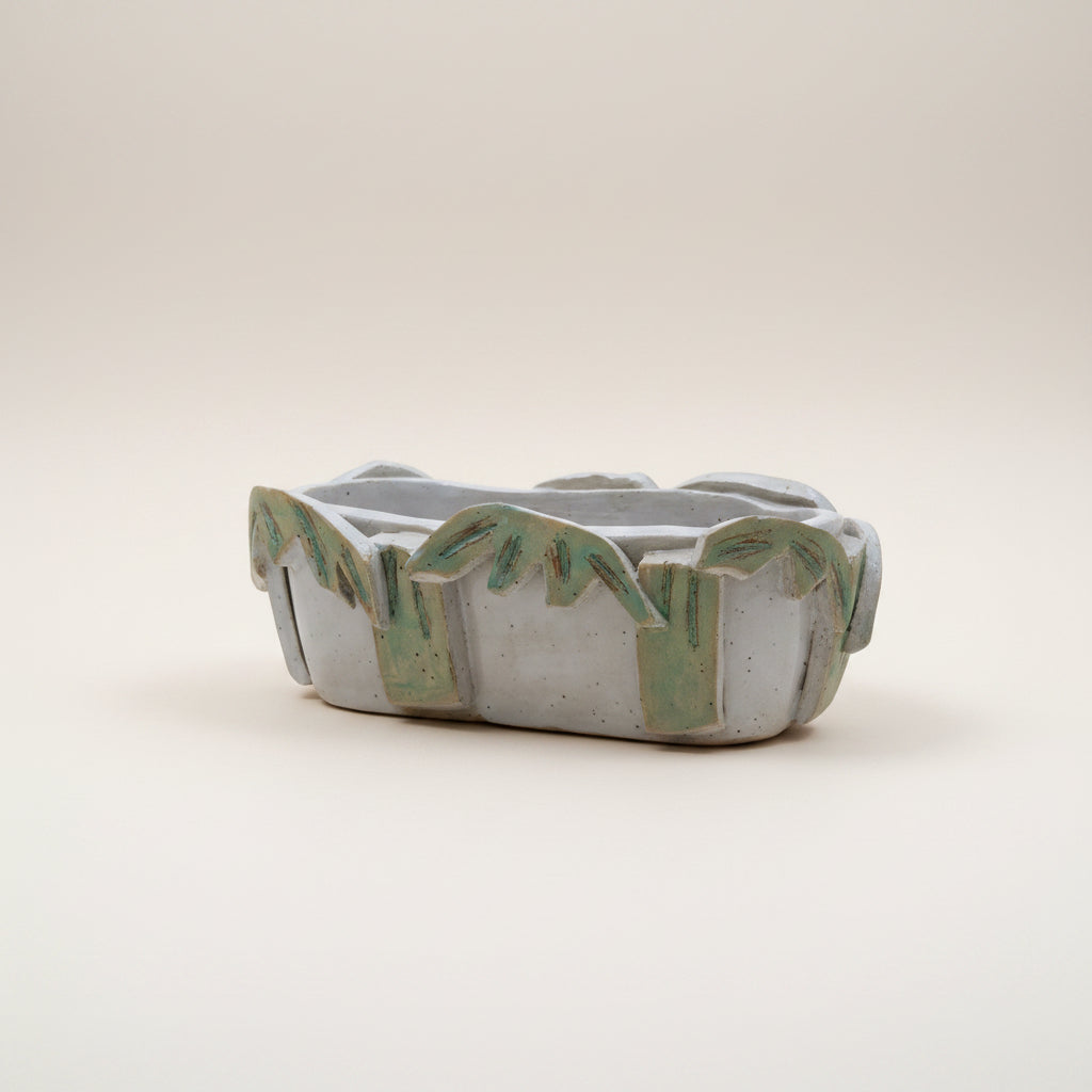 Ceramic planter with decorative edge on a white surface