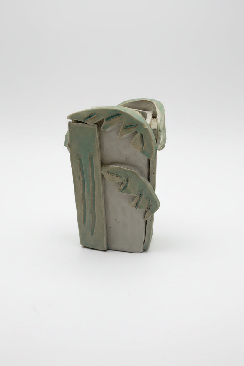 Ceramic vase with palm design on a plain background
