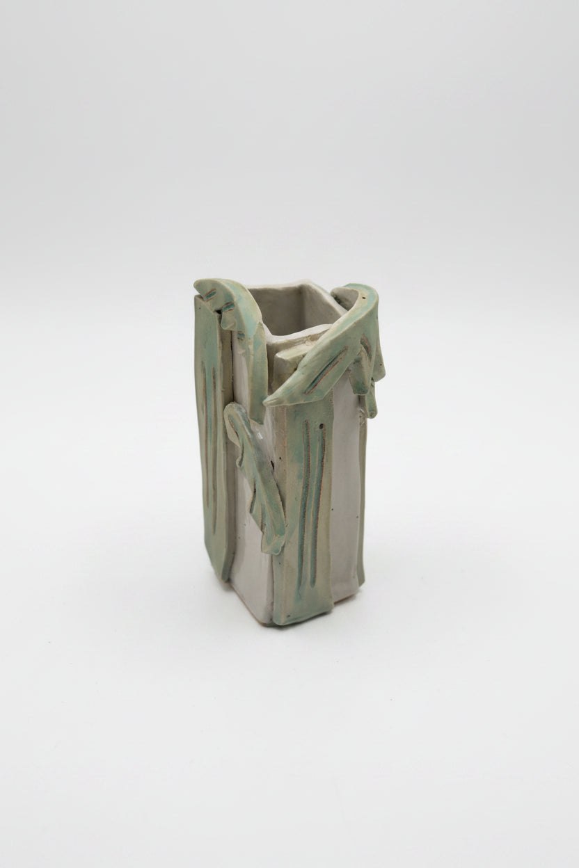 Ceramic vase with a unique palm design on a white surface