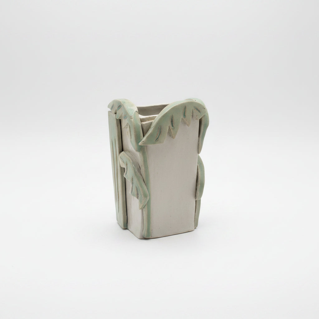 Ceramic vase with palm design on a plain background