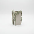 Ceramic vase with palm design on a plain background