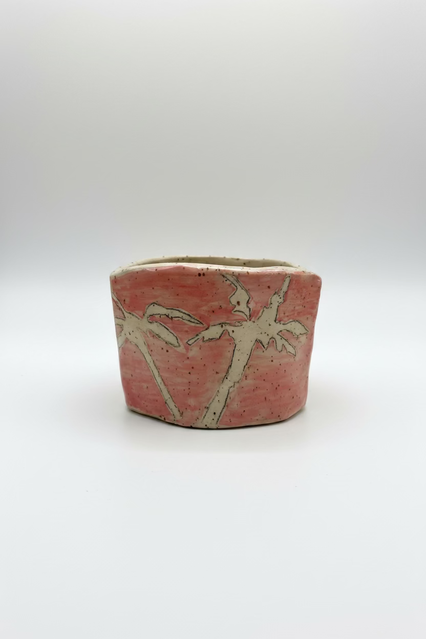 Ceramic pot with palm tree design on a plain background