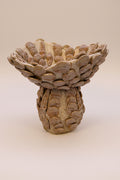 Decorative ceramic bowl with shell design on a beige background