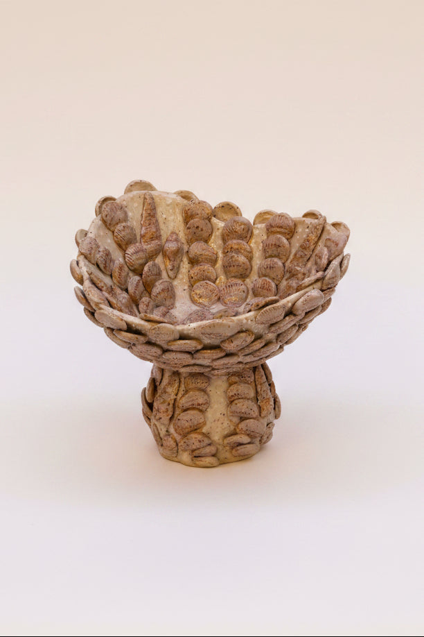 Decorative ceramic bowl with textured surface on a beige background